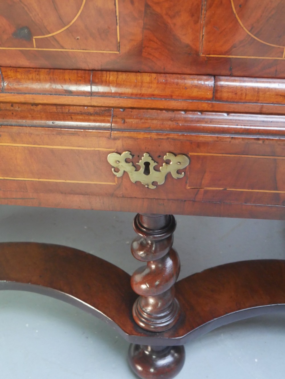 A late 17th-century William and Mary walnut chest on stand featuring multiple drawers with feather inlay, barley twist legs, and bun feet. View III