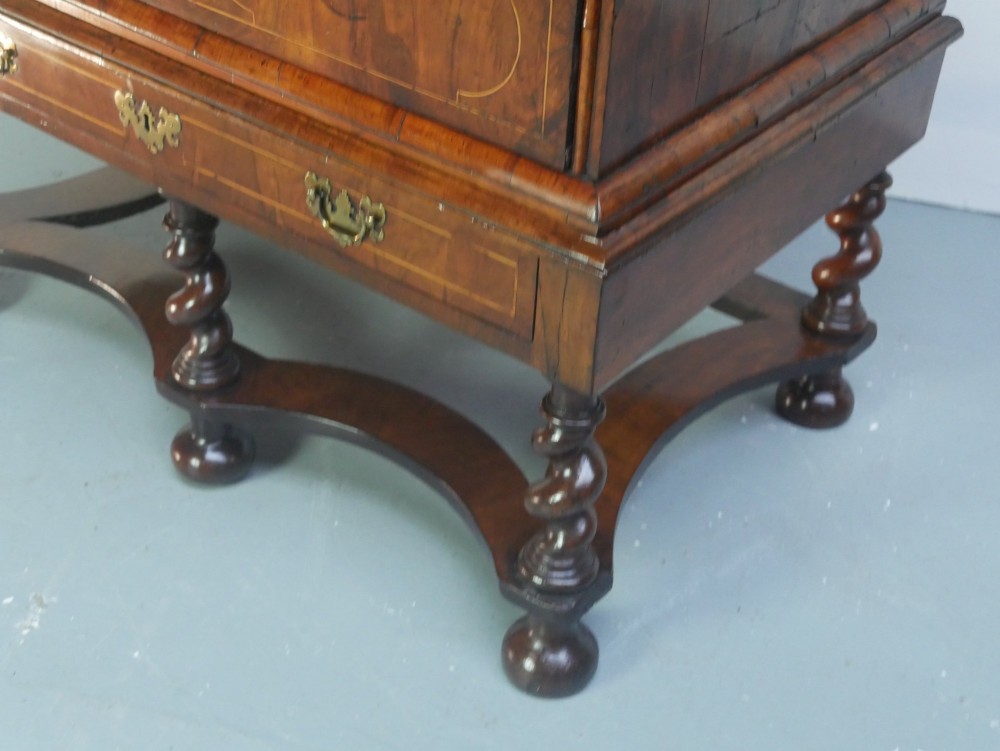 A late 17th-century William and Mary walnut chest on stand featuring multiple drawers with feather inlay, barley twist legs, and bun feet. View IV