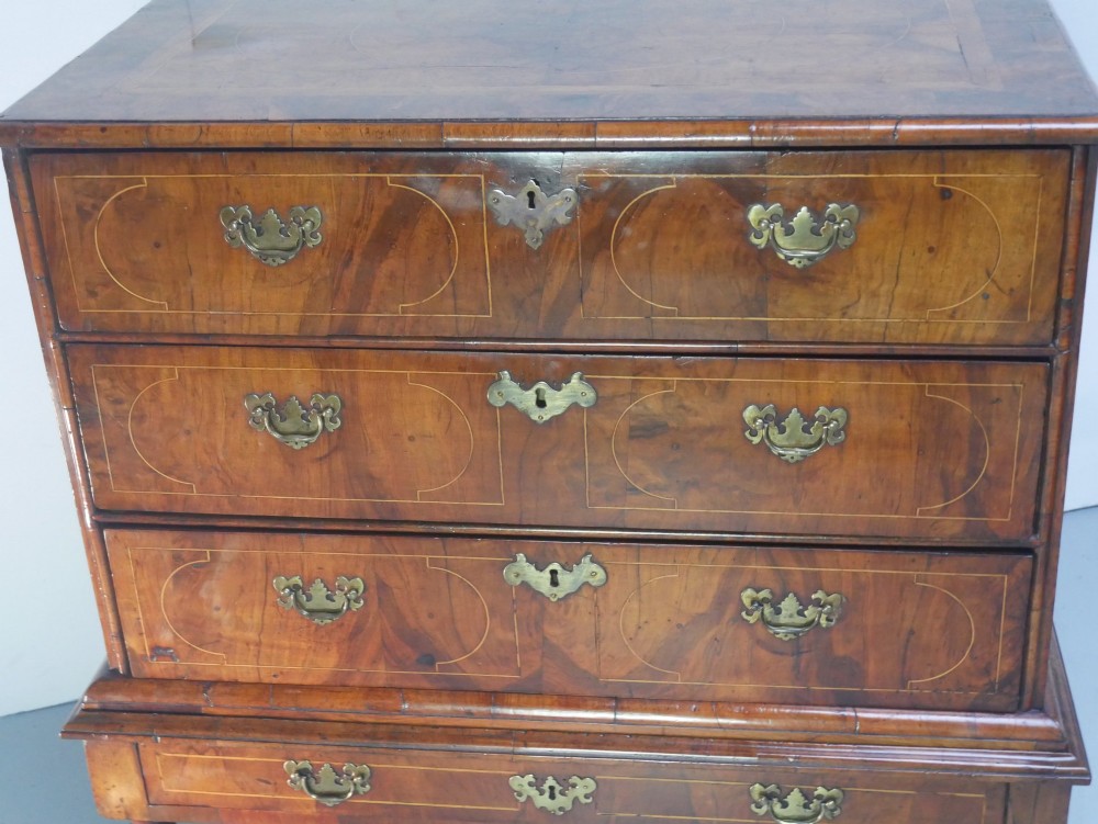 A late 17th-century William and Mary walnut chest on stand featuring multiple drawers with feather inlay, barley twist legs, and bun feet. View VI