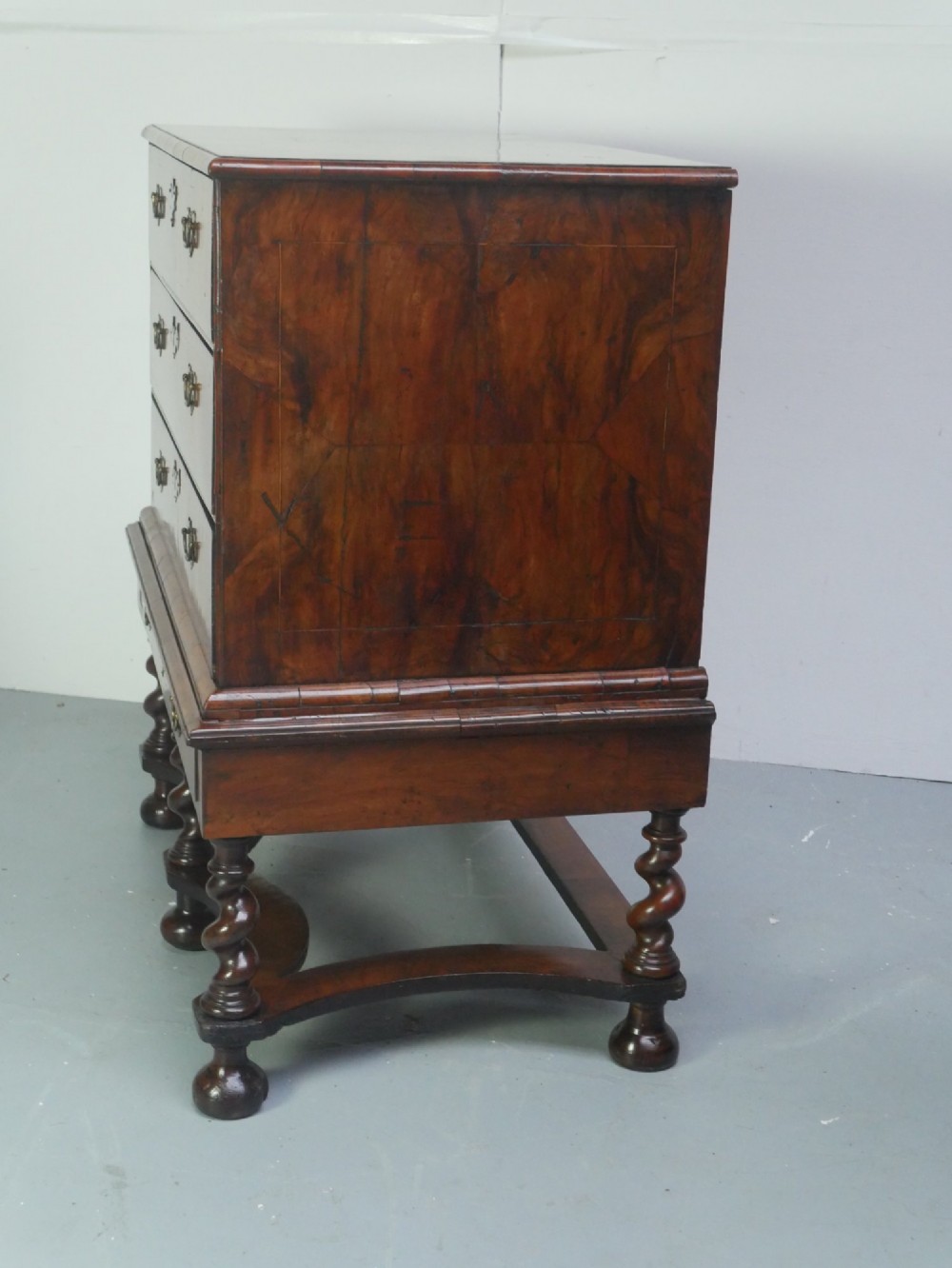 A late 17th-century William and Mary walnut chest on stand featuring multiple drawers with feather inlay, barley twist legs, and bun feet. View VII