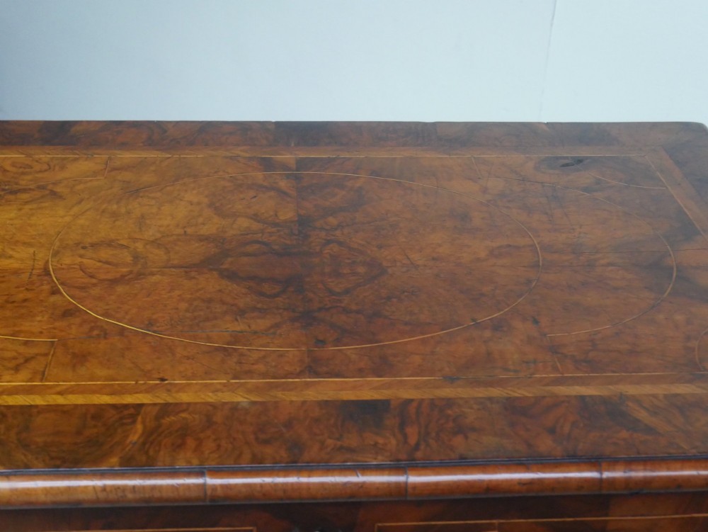 A late 17th-century William and Mary walnut chest on stand featuring multiple drawers with feather inlay, barley twist legs, and bun feet. View XI