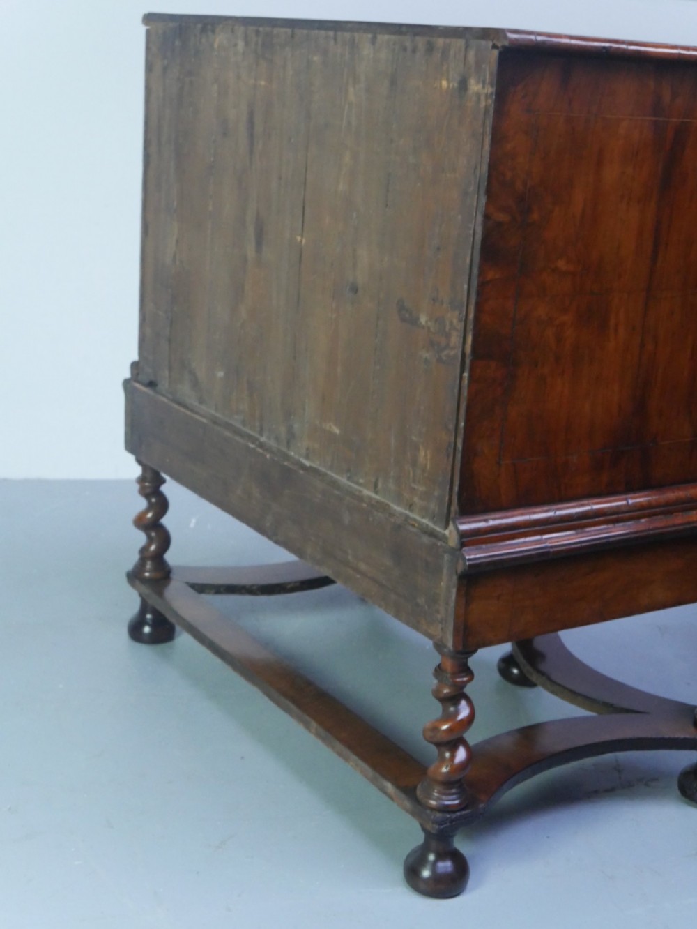 A late 17th-century William and Mary walnut chest on stand featuring multiple drawers with feather inlay, barley twist legs, and bun feet. View XII