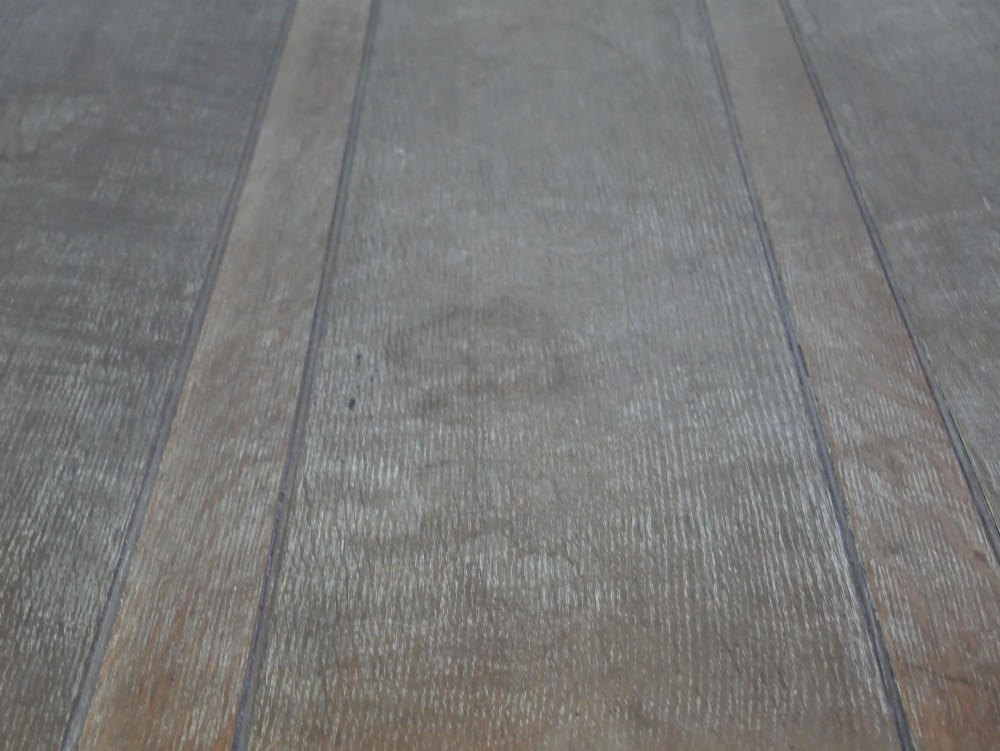 A square limed oak dining table featuring reeded legs, an X-shaped cross stretcher, and a draw-leaf top mechanism. View III