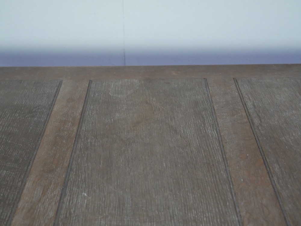 A square limed oak dining table featuring reeded legs, an X-shaped cross stretcher, and a draw-leaf top mechanism. View IV