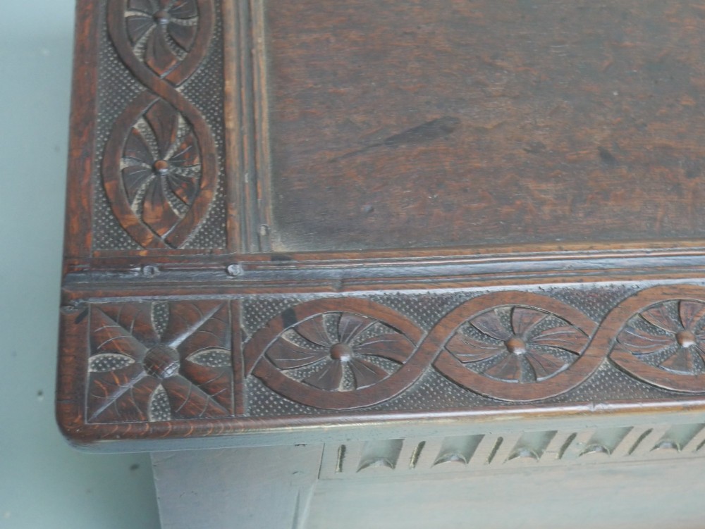 A dark brown oak coffer featuring a carved fluted frieze, double front panels, and a hinged lid with carved geometric border details. View XI