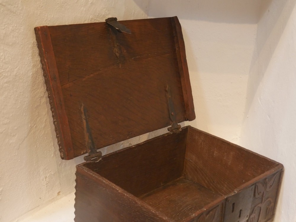A dark carved oak box with hand-carved botanical motifs on the front panel and a central iron lockplate. View VII