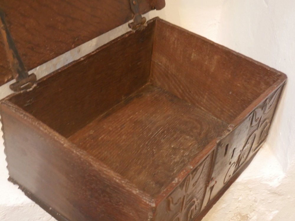 A dark carved oak box with hand-carved botanical motifs on the front panel and a central iron lockplate. View VIII