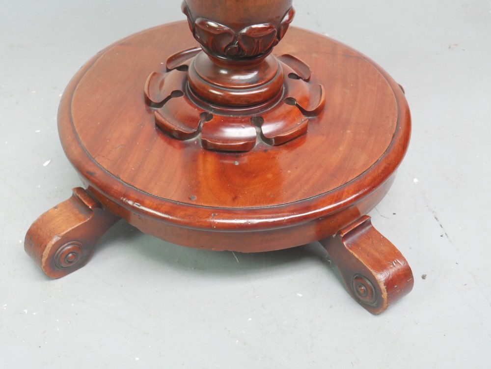 A carved mahogany standing dinner gong featuring a circular frame with a suspended beaten brass gong disc on a turned pedestal. View IV