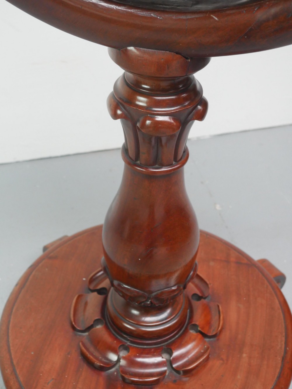 A carved mahogany standing dinner gong featuring a circular frame with a suspended beaten brass gong disc on a turned pedestal. View V