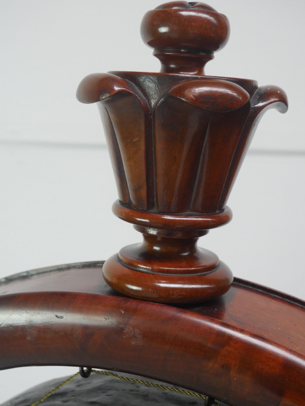 A carved mahogany standing dinner gong featuring a circular frame with a suspended beaten brass gong disc on a turned pedestal. View VI