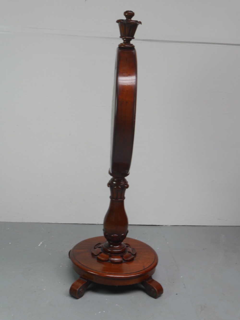 A carved mahogany standing dinner gong featuring a circular frame with a suspended beaten brass gong disc on a turned pedestal. View VIII