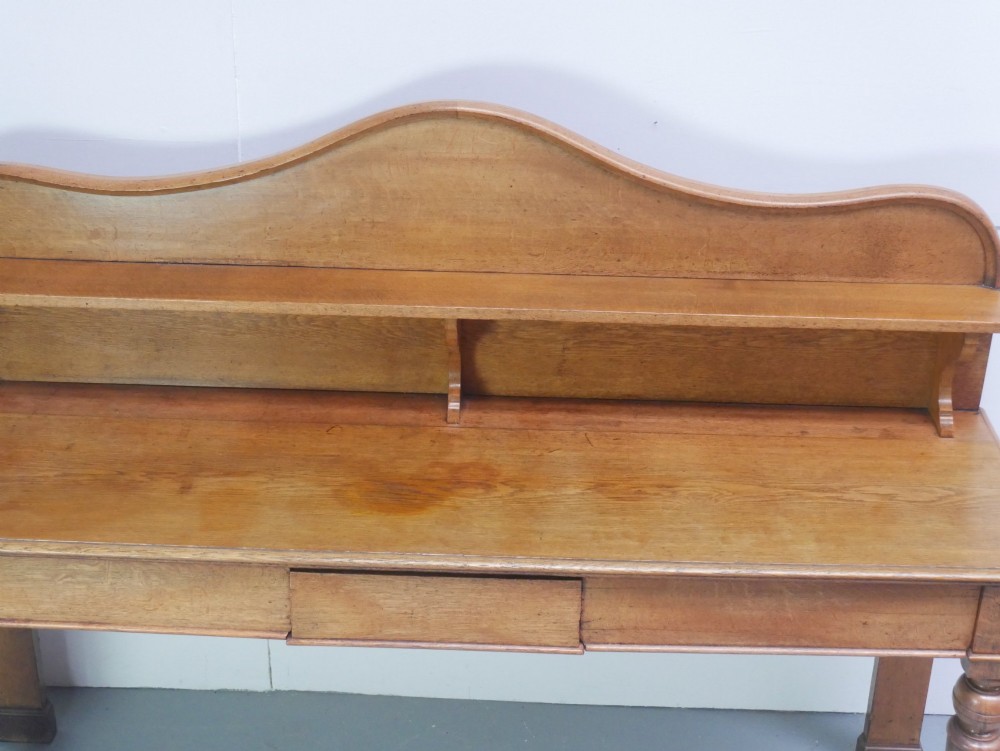 A large Victorian oak serving table featuring a raised back gallery shelf, frieze drawers, and turned front legs. View V