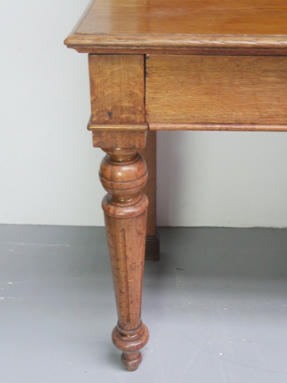 A large Victorian oak serving table featuring a raised back gallery shelf, frieze drawers, and turned front legs. View VI