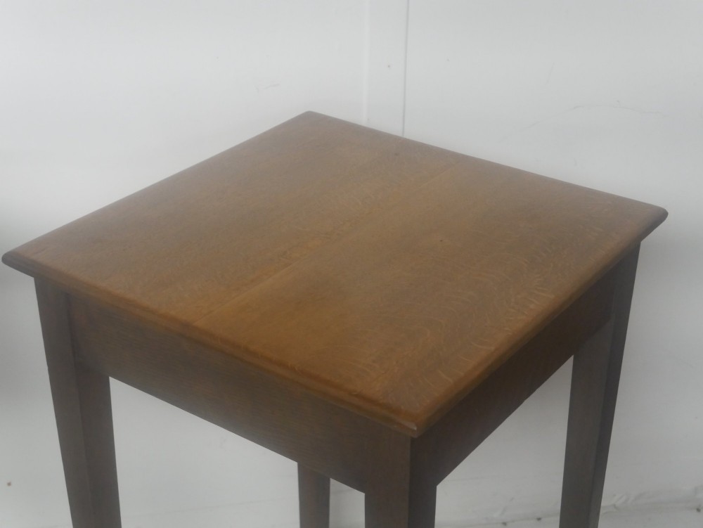 A pair of matching square wooden lamp tables made from warm brown oak, featuring square tops and simple tapered legs. View IV