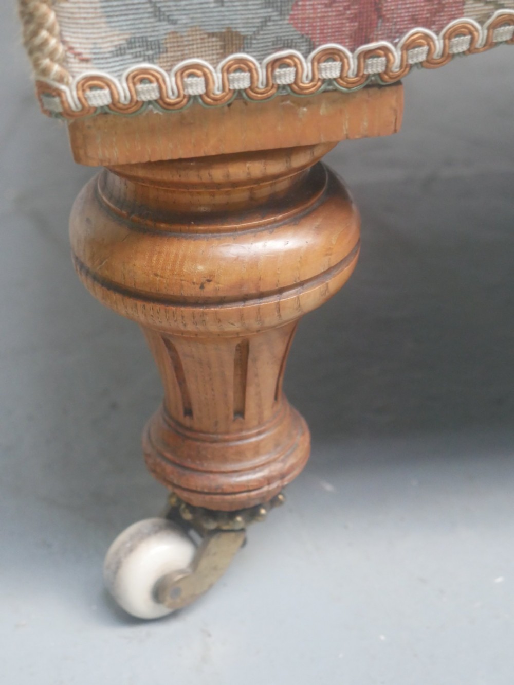 A 19th-century Howard style armchair with button-tufted floral tapestry upholstery, low padded arms, turned timber legs, and ceramic castors. View II