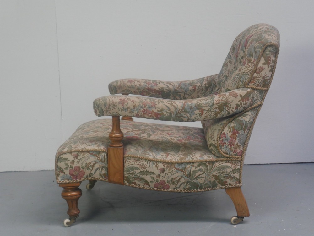 A 19th-century Howard style armchair with button-tufted floral tapestry upholstery, low padded arms, turned timber legs, and ceramic castors. View III