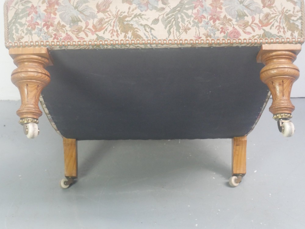 A 19th-century Howard style armchair with button-tufted floral tapestry upholstery, low padded arms, turned timber legs, and ceramic castors. View VIII