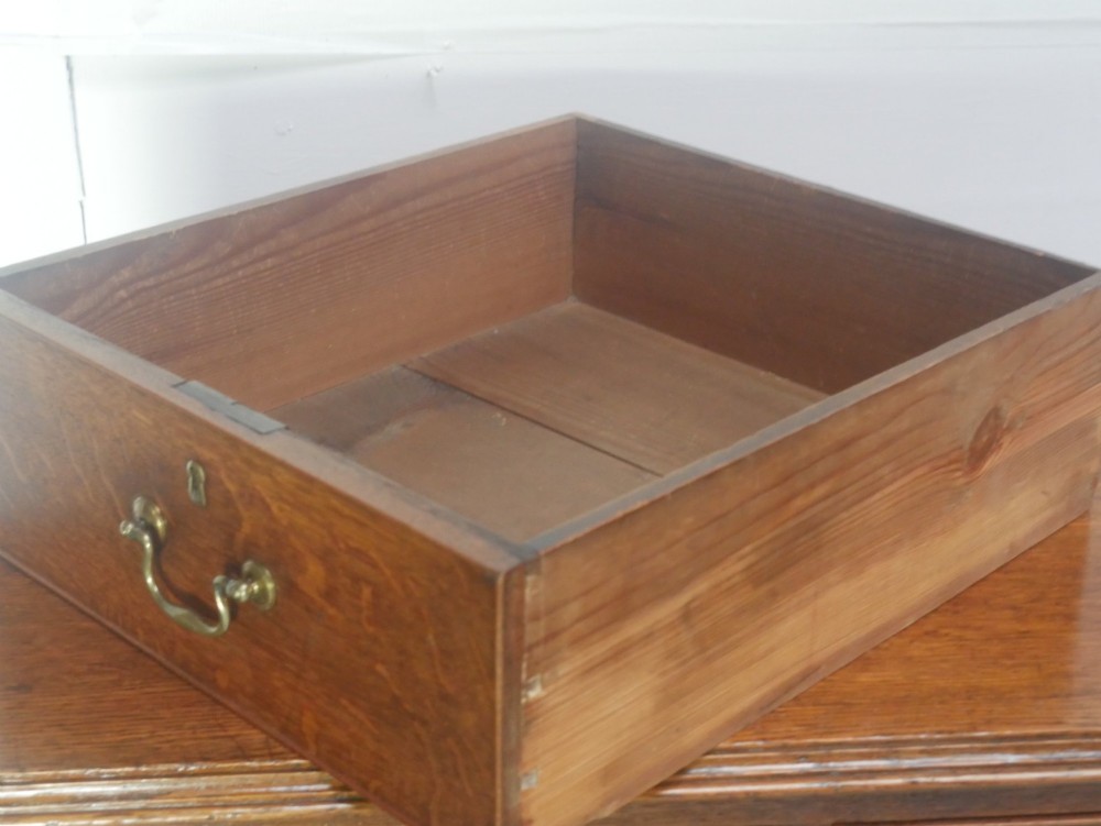 A Georgian oak chest of drawers featuring two short drawers over three long graduated drawers with brass swan-neck handles and bracket feet. View VIII