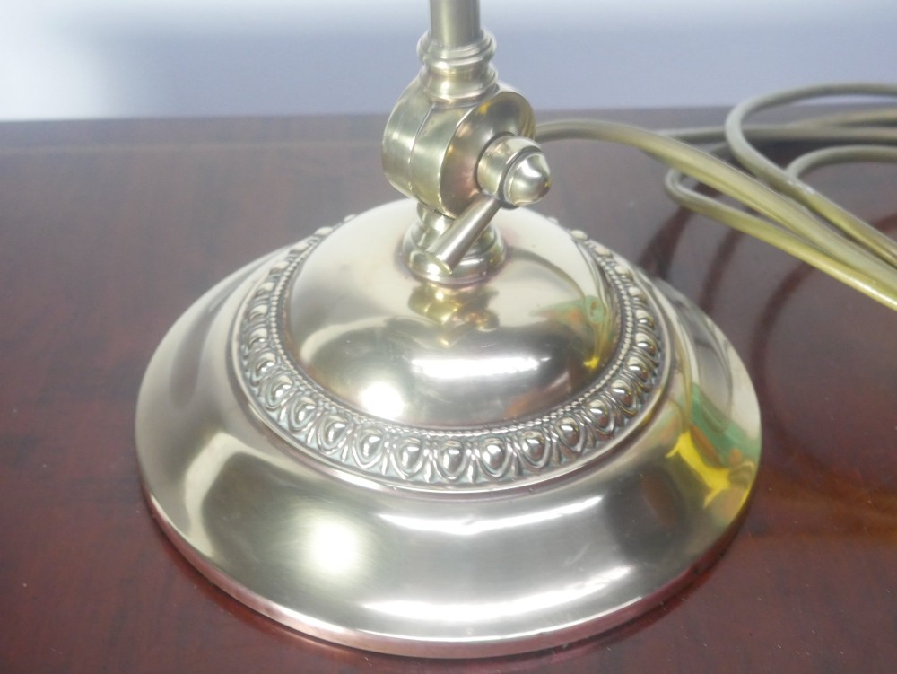 A vintage brass bankers desk lamp featuring a weighted round base, curved stem, and adjustable dark metal shade. View II