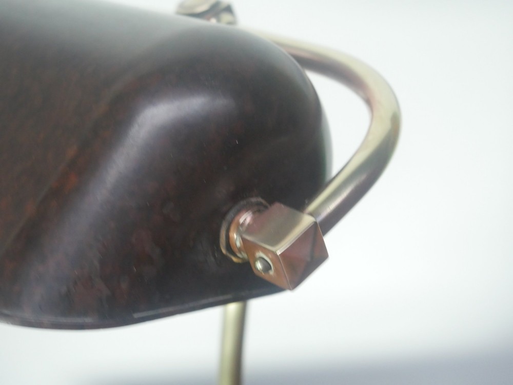 A vintage brass bankers desk lamp featuring a weighted round base, curved stem, and adjustable dark metal shade. View III