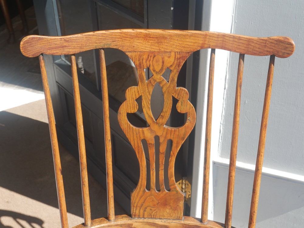 A Georgian comb back Windsor armchair featuring vertical wooden spindles, a pierced central splat, curved armrests, and turned legs. View II