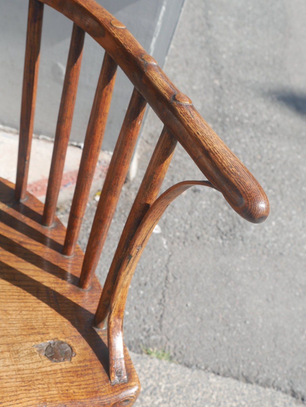 A Georgian comb back Windsor armchair featuring vertical wooden spindles, a pierced central splat, curved armrests, and turned legs. View III