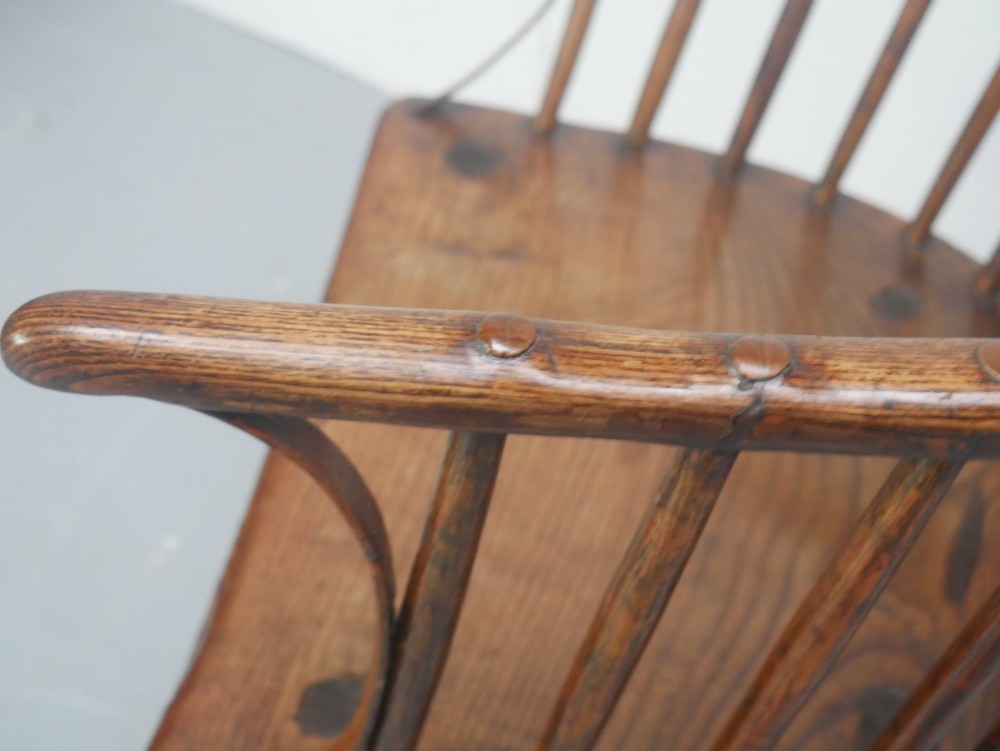 A Georgian comb back Windsor armchair featuring vertical wooden spindles, a pierced central splat, curved armrests, and turned legs. View XII