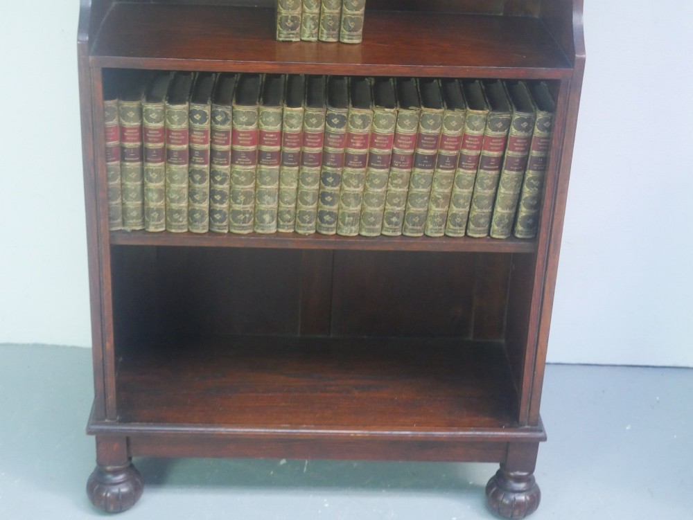 A tall, narrow 1920s dark oak open bookcase featuring five shelves and turned bun feet. View V