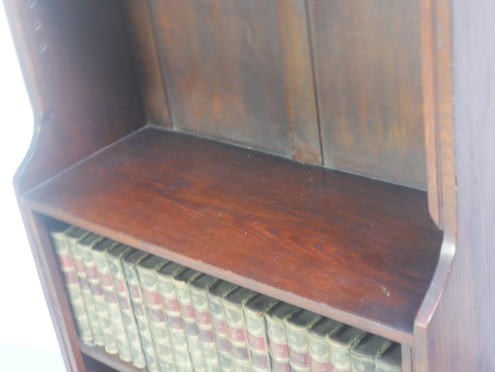 A tall, narrow 1920s dark oak open bookcase featuring five shelves and turned bun feet. View VI