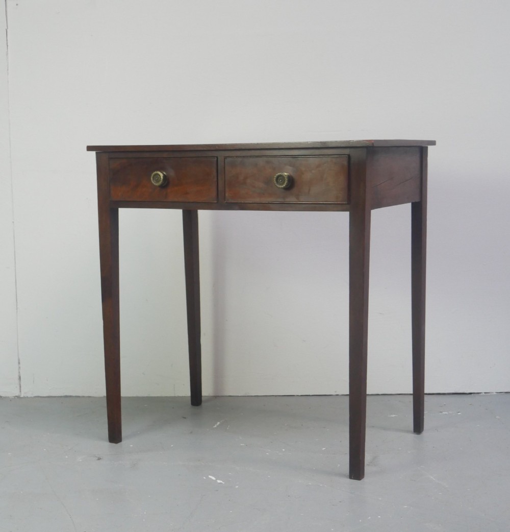 A rectangular Georgian mahogany side table with two frieze drawers, circular brass knobs, and four straight tapered legs. View II