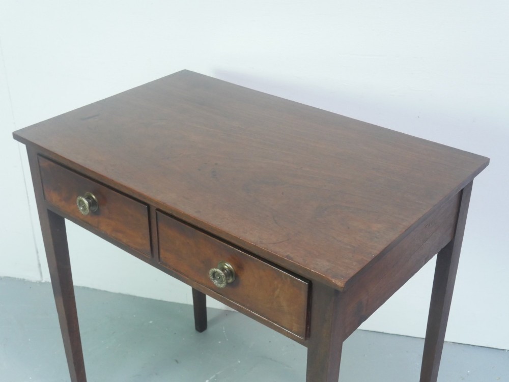 A rectangular Georgian mahogany side table with two frieze drawers, circular brass knobs, and four straight tapered legs. View III