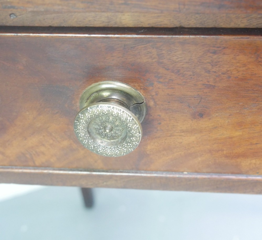 A rectangular Georgian mahogany side table with two frieze drawers, circular brass knobs, and four straight tapered legs. View V