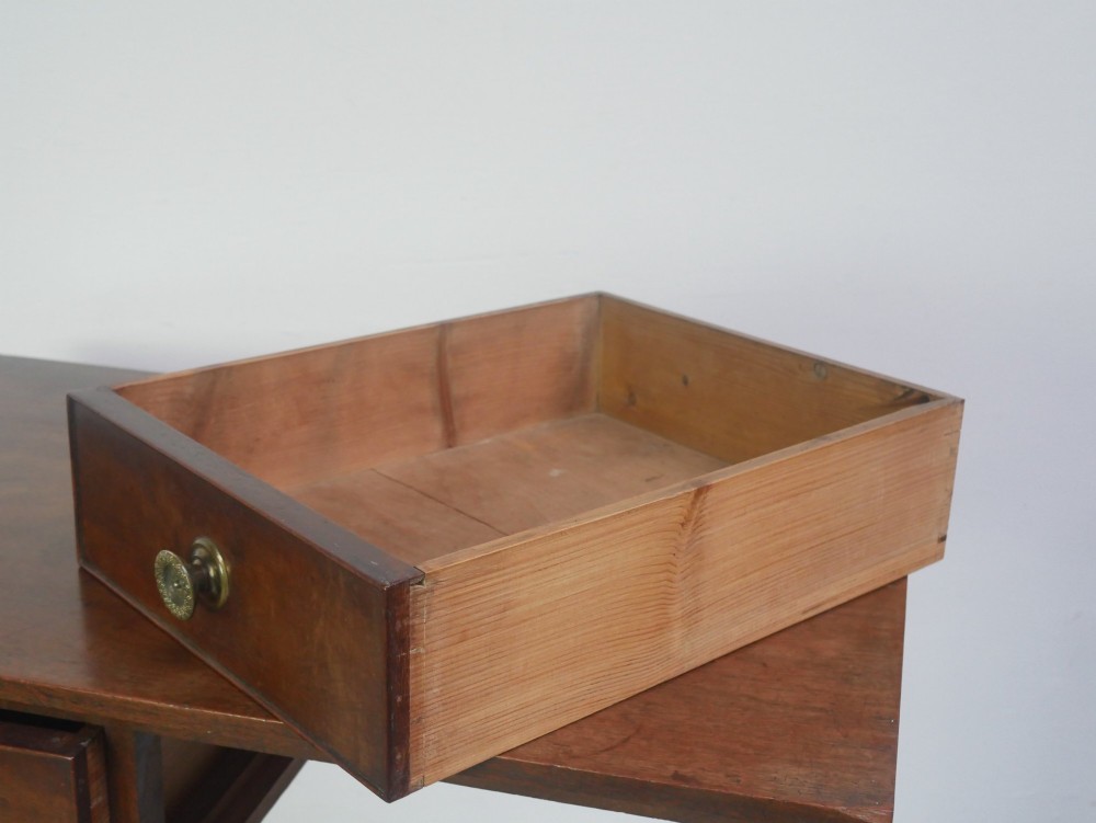 A rectangular Georgian mahogany side table with two frieze drawers, circular brass knobs, and four straight tapered legs. View VI