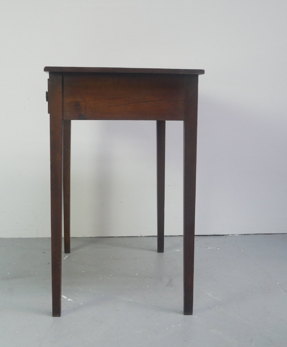 A rectangular Georgian mahogany side table with two frieze drawers, circular brass knobs, and four straight tapered legs. View VII