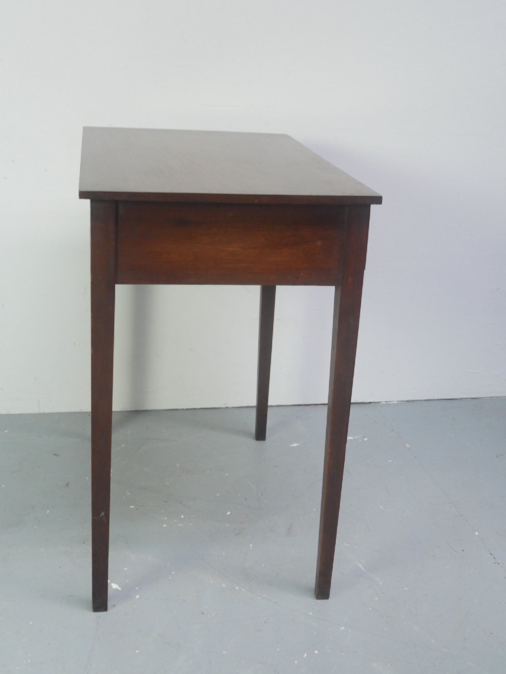 A rectangular Georgian mahogany side table with two frieze drawers, circular brass knobs, and four straight tapered legs. View IX