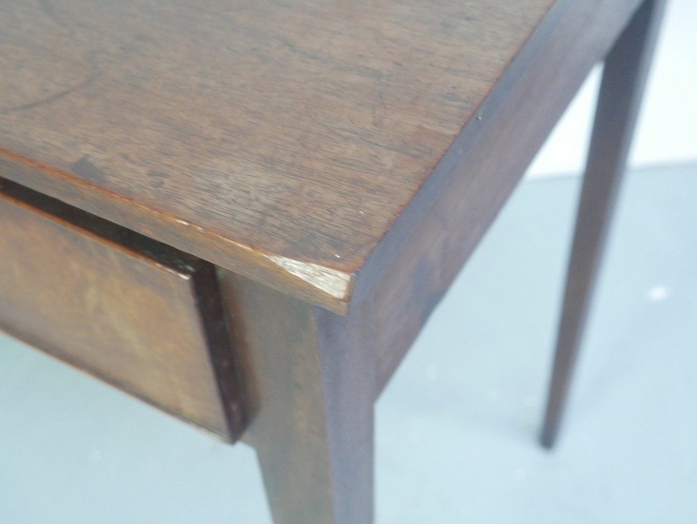 A rectangular Georgian mahogany side table with two frieze drawers, circular brass knobs, and four straight tapered legs. View X