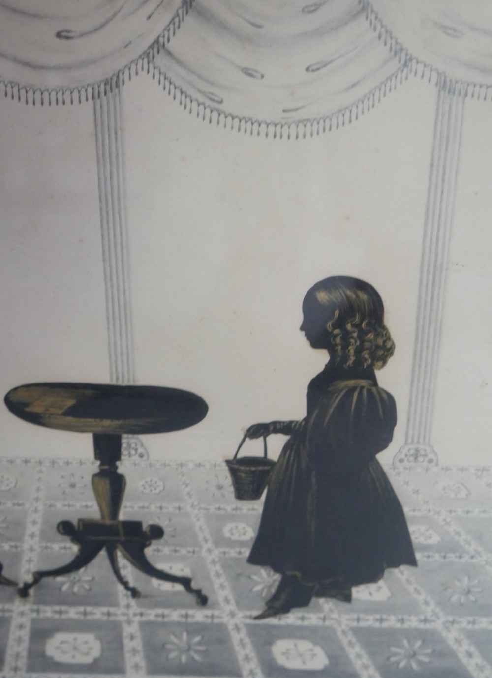 A framed antique Regency silhouette depicting a family group in a decorative interior setting set within an ebonised moulded frame with brass slip. View III
