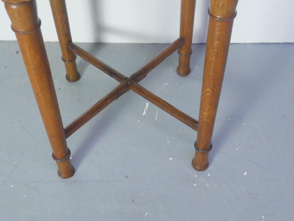 A round 1920s oak lamp table featuring turned legs supported by an X-frame stretcher. View III