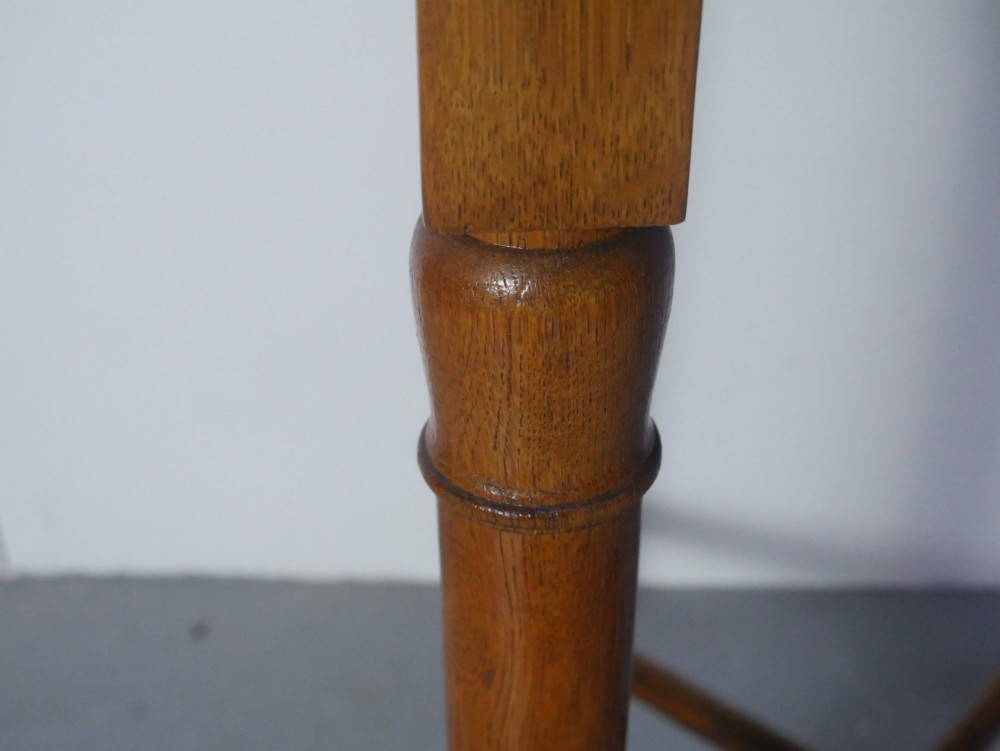 A round 1920s oak lamp table featuring turned legs supported by an X-frame stretcher. View VI
