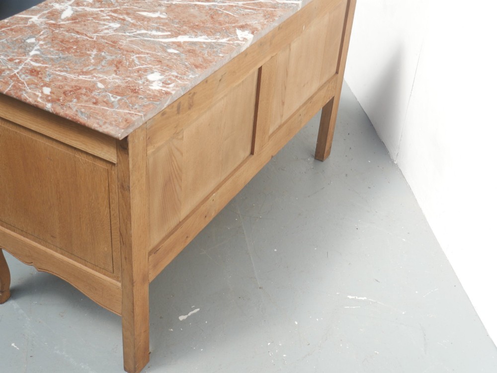 A French provincial style oak chest of drawers featuring two moulded panel drawers, ornate cast brass handles, cabriole legs, and a red-toned marble top. View V