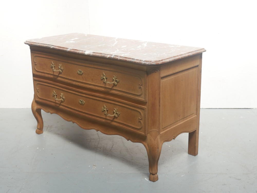 A French provincial style oak chest of drawers featuring two moulded panel drawers, ornate cast brass handles, cabriole legs, and a red-toned marble top. View VIII