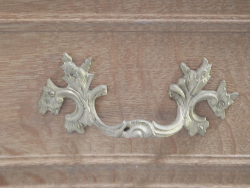 A French provincial style oak chest of drawers featuring two moulded panel drawers, ornate cast brass handles, cabriole legs, and a red-toned marble top. View IX