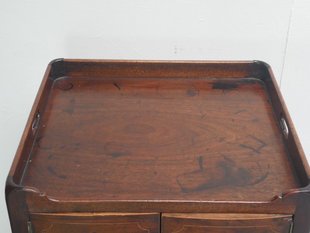 A Georgian mahogany bedside cabinet with a tray top gallery, double inlaid cupboard doors, a lower drawer, and square legs. View III