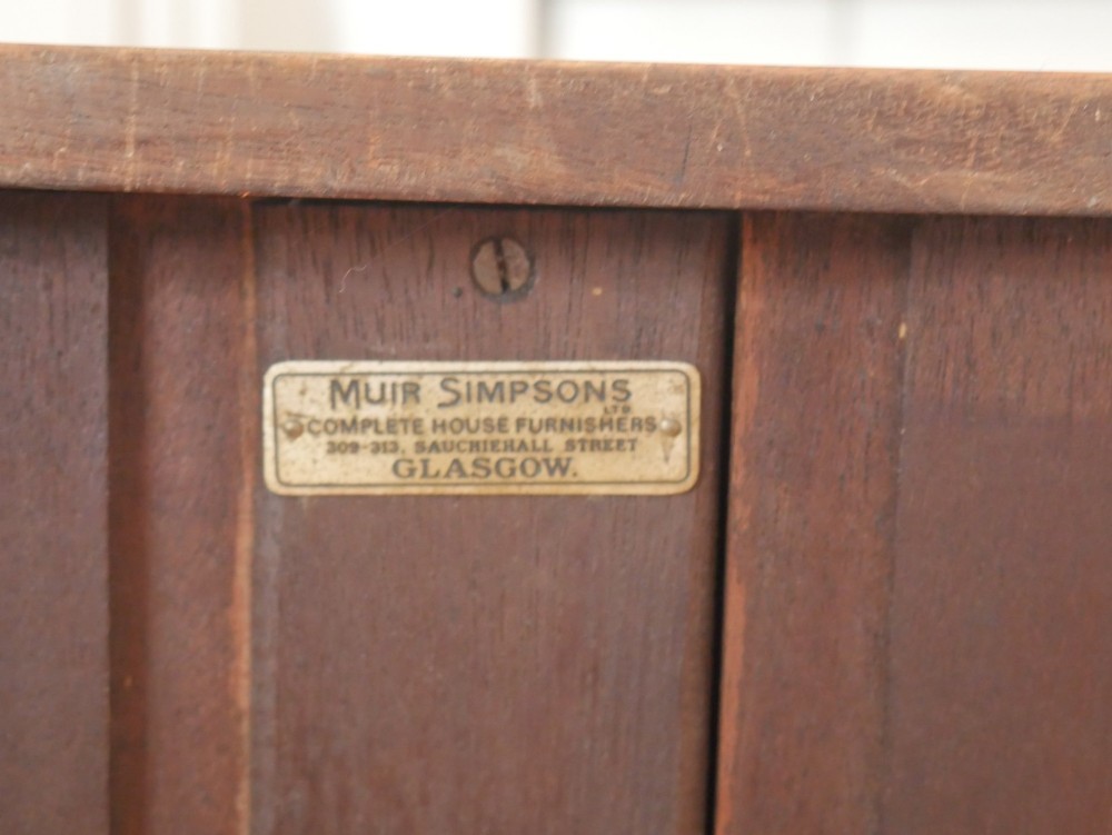 An antique dark mahogany bowfront chest of drawers featuring four graduated drawers with brass ring handles and splayed bracket feet. View VIII