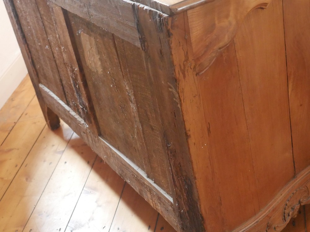 An eighteenth-century French provincial walnut commode featuring three drawers with brass handles, a carved apron, and short cabriole legs. View III