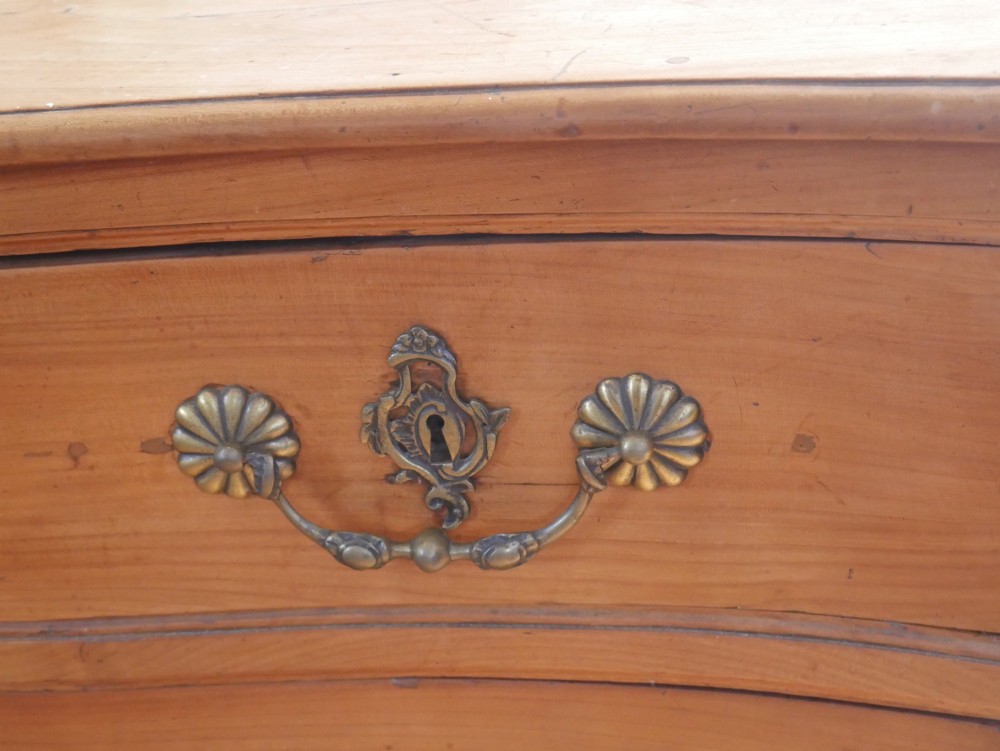An eighteenth-century French provincial walnut commode featuring three drawers with brass handles, a carved apron, and short cabriole legs. View VIII