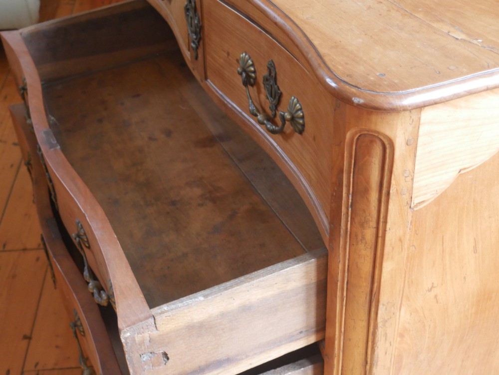 An eighteenth-century French provincial walnut commode featuring three drawers with brass handles, a carved apron, and short cabriole legs. View IX