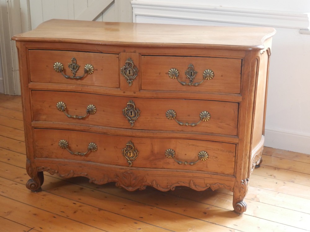 An eighteenth-century French provincial walnut commode featuring three drawers with brass handles, a carved apron, and short cabriole legs. View XI