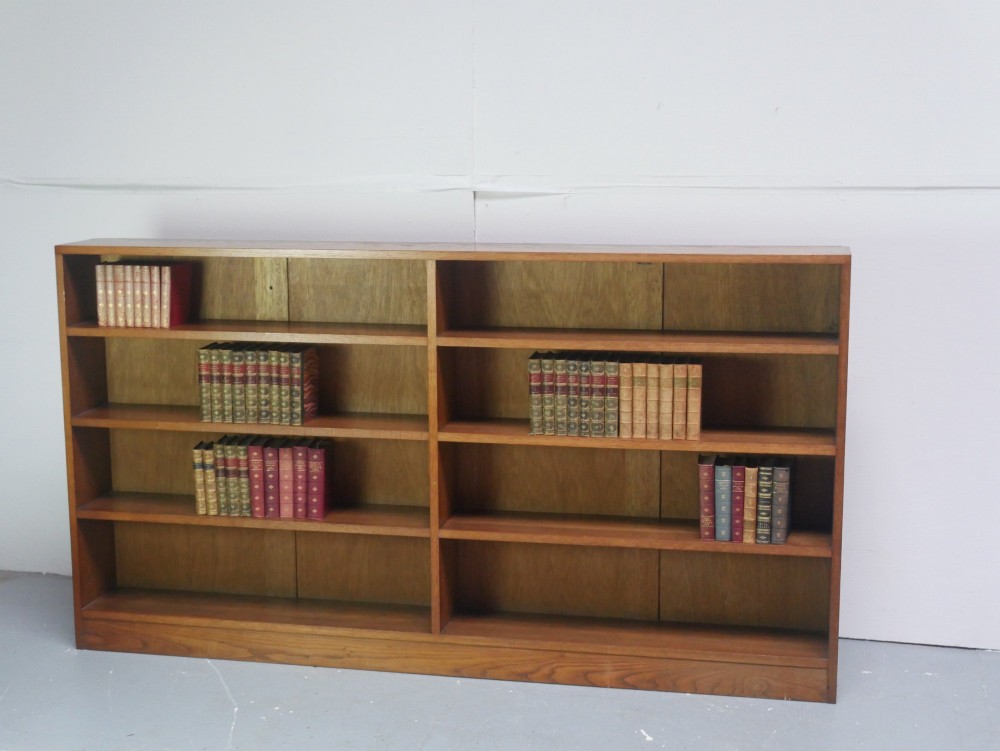 A wide, low Arts and Crafts oak bookcase featuring double open bays with multiple horizontal shelves. View II
