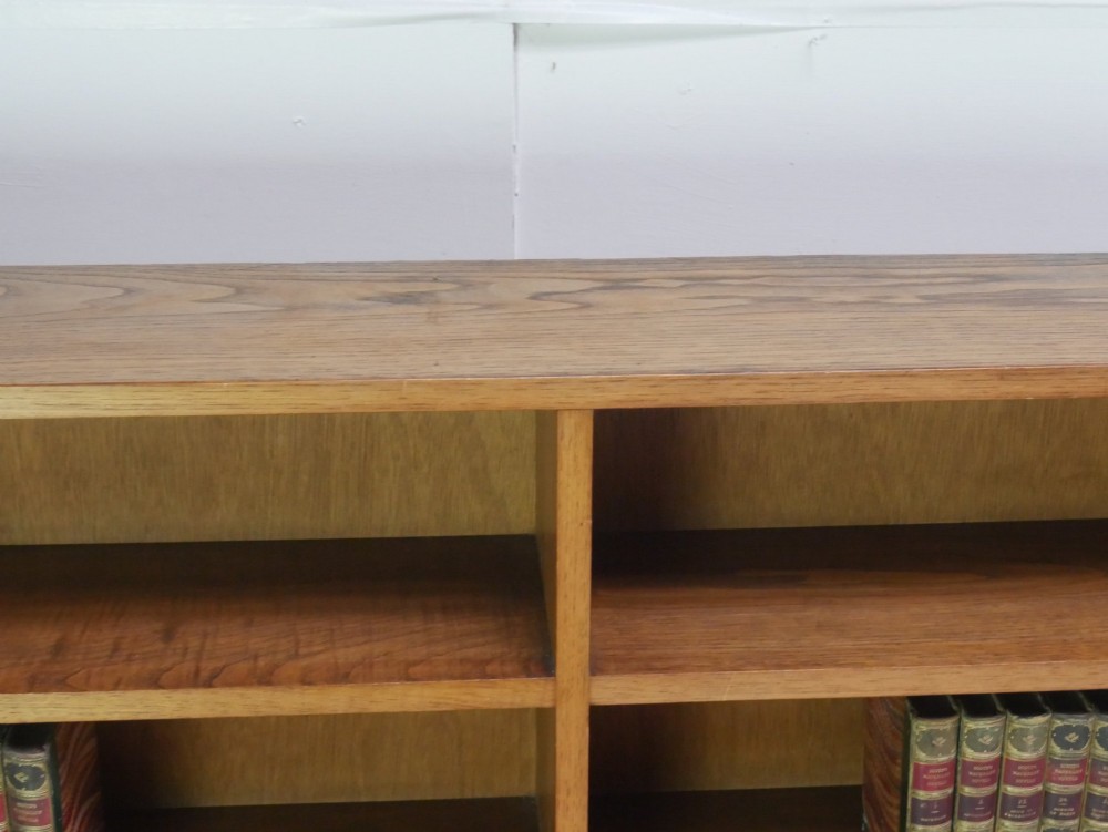 A wide, low Arts and Crafts oak bookcase featuring double open bays with multiple horizontal shelves. View V